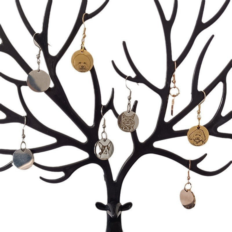 Close-up of custom pet face earrings displayed on jewelry tree