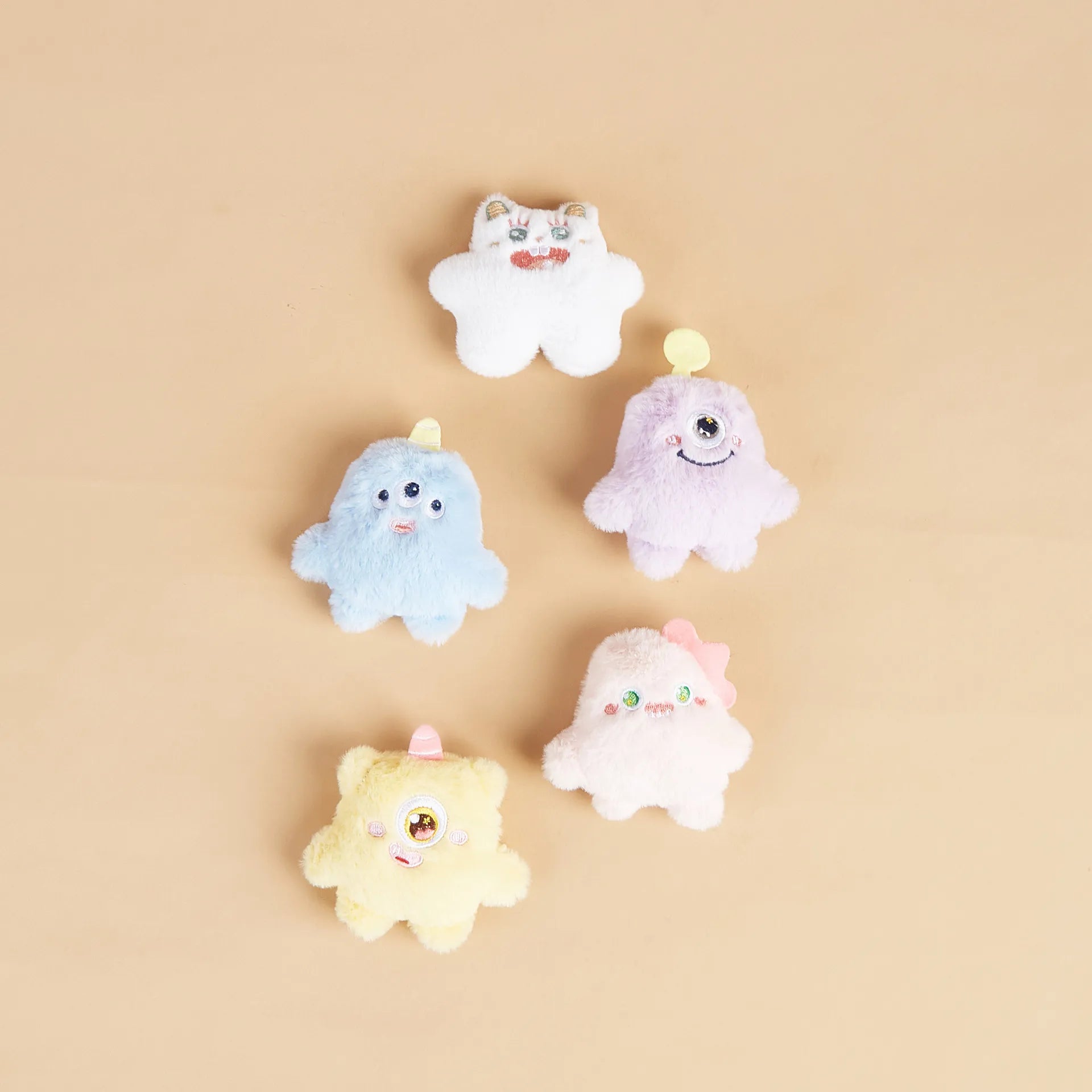 Flat lay of multi-color plush one-eyed pet toys (set 2)