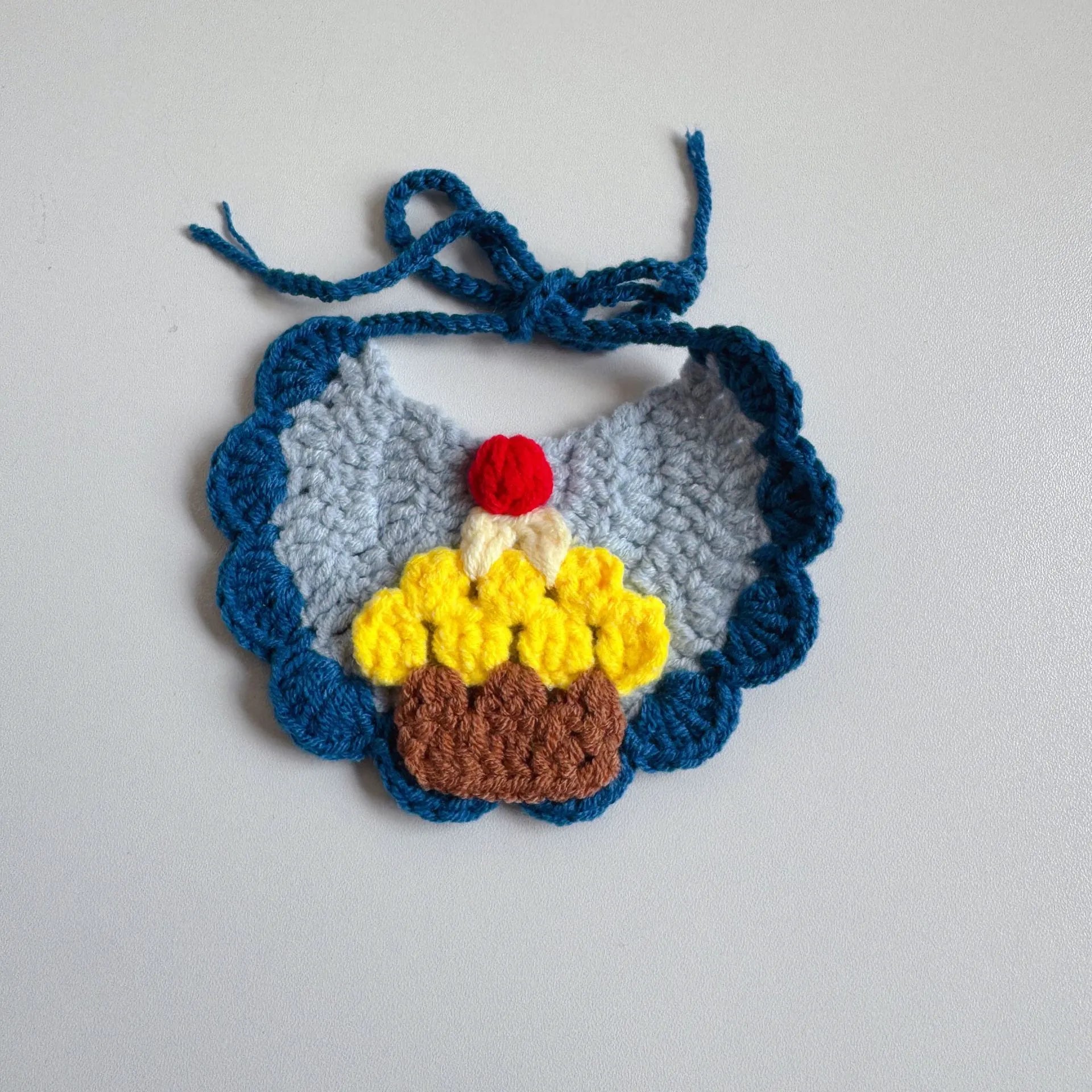 Blue knitted pet party hat with pink pom-pom