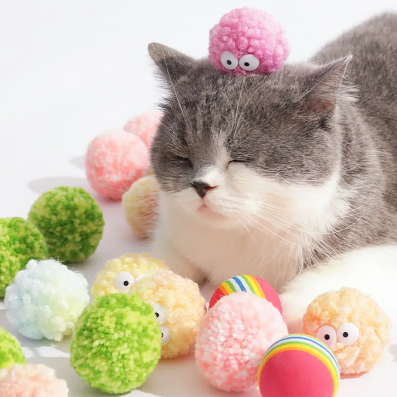 Cat playing with colorful egg-shaped yarn balls