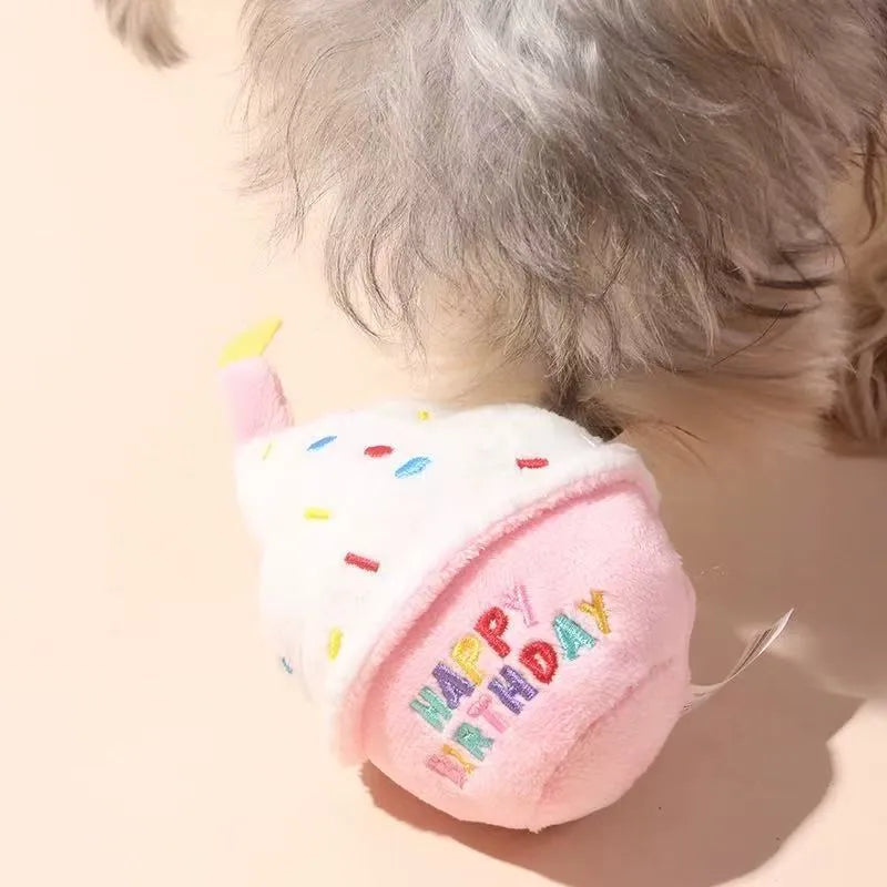 Pet interacting with plush birthday cake toy