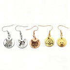Flat lay of custom pet face earrings in gold and silver styles
