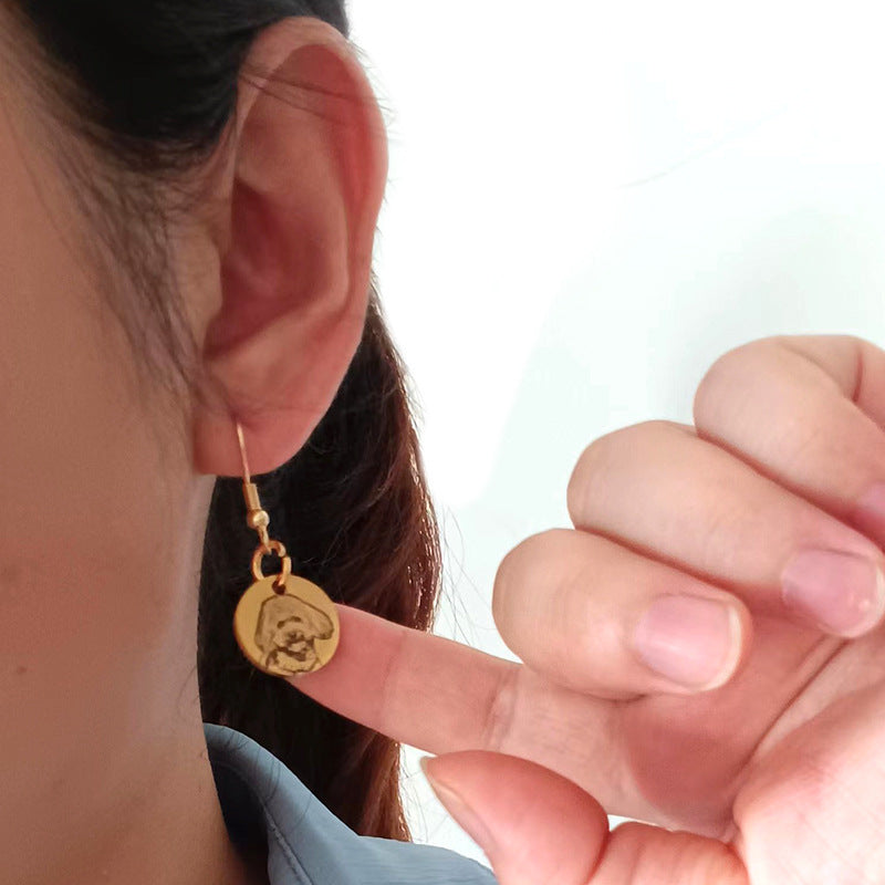 Custom pet face earring shown with finger for size reference
