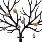 Close-up of custom pet face earrings displayed on jewelry tree
