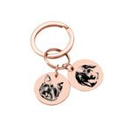 Rose gold pet face keychain with two engraved pendants for pets.
