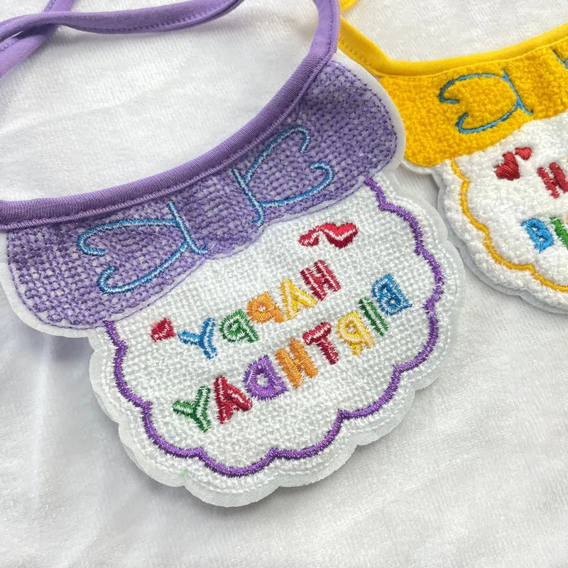 Embroidery detail of “Happy Birthday” on bib