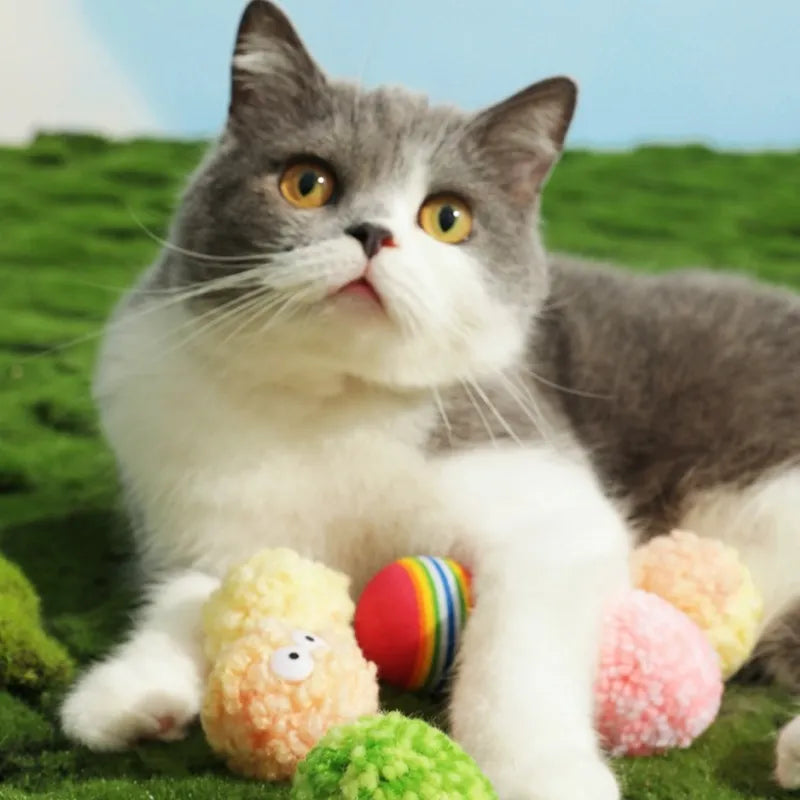 Cat beside pastel egg-shaped yarn balls